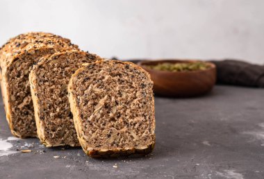 Çok tahıl ekmeği susam ve kabak çekirdeği ile parçalar halinde kesin. Kopya alanı.