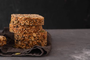 Çok tahıl ekmeği susam ve kabak çekirdeği ile parçalar halinde kesin. Kopya alanı.
