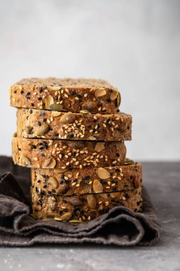 Çok tahıl ekmeği susam ve kabak çekirdeği ile parçalar halinde kesin. Kopya alanı.