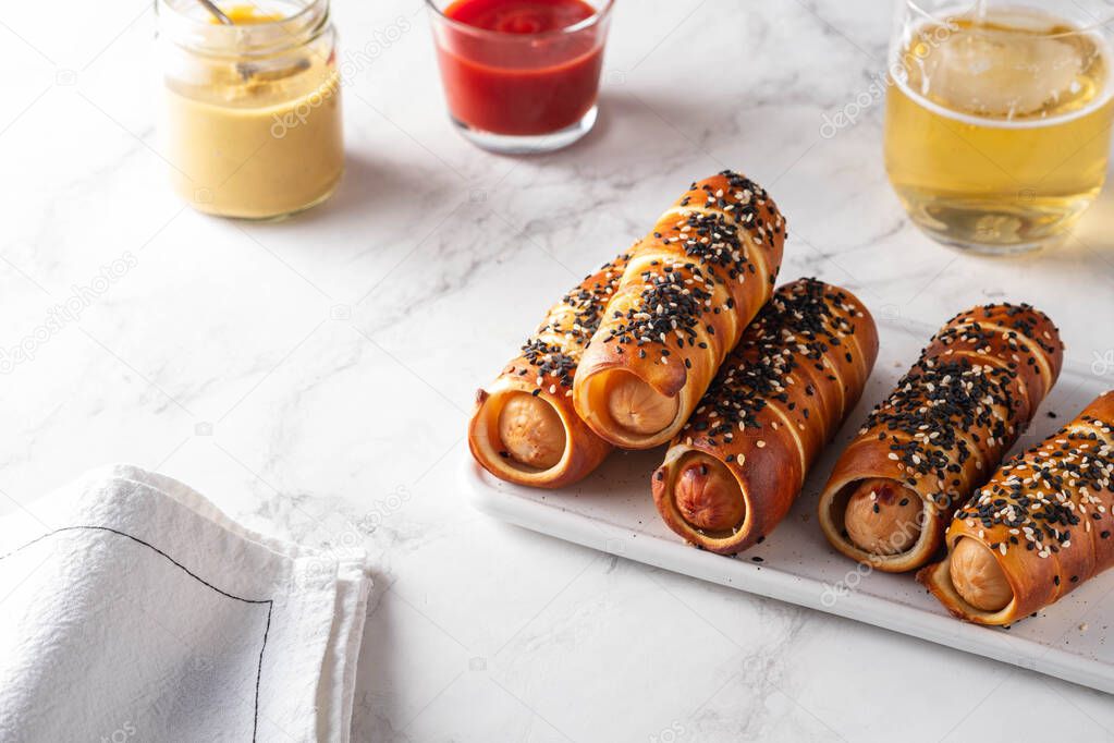 Pretzel dogs with sausages, with ketchup white background.