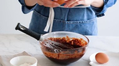 Şefin elleri yumurta kırıyor. Yumurta yavaş çekimde kırılır. Ev yapımı çikolatalı pasta yapıyorum. Pişirme malzemeleri