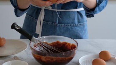 Şefin elleri yumurta kırıyor. Yumurta yavaş çekimde kırılır. Ev yapımı çikolatalı pasta yapıyorum. Pişirme malzemeleri