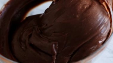 Çikolata hamuru karıştırmak veya kek, kurabiye, pasta yapmak için hamuru karıştırmak. Karıştırıcı çikolatayı kasede dövüyor.