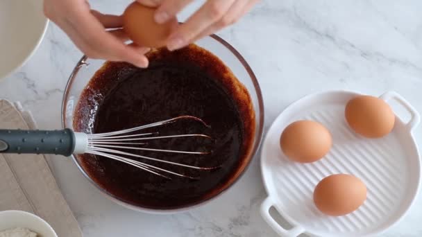 Χέρια σεφ σπάνε αυγά. Σπάσιμο αυγού σε αργή κίνηση. Φτιάχνω σπιτικό κέικ σοκολάτας. Συστατικά αρτοποιίας — Αρχείο Βίντεο