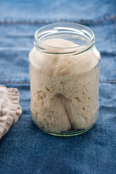 Lievito naturale per pane in un barattolo di vetro. Un prodotto vivo. Il concetto di una dieta sana. Antipasto di pasta madre — Foto Stock