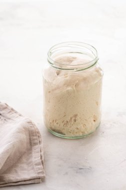 Cam kavanozdaki ekmek için doğal yapraklar. Canlı bir ürün. Sağlıklı beslenme kavramı. Ekşi hamur başlatıcı