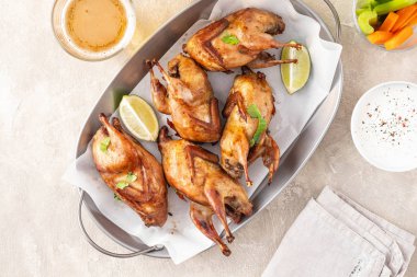 Hafif arka planda kızarmış bıldırcın, kereviz, havuç ve sos..