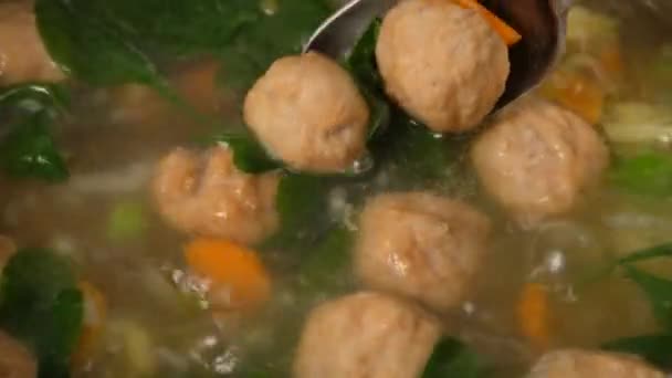 Hausgemachte Gemüsesuppe mit Frikadellen in der Pfanne. Spinat. Nahaufnahme. — Stockvideo