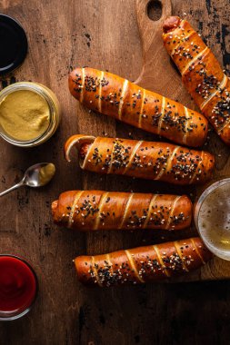Sosisli simit, ketçap sosu, ahşap arka plan. Boşluğu kopyala.