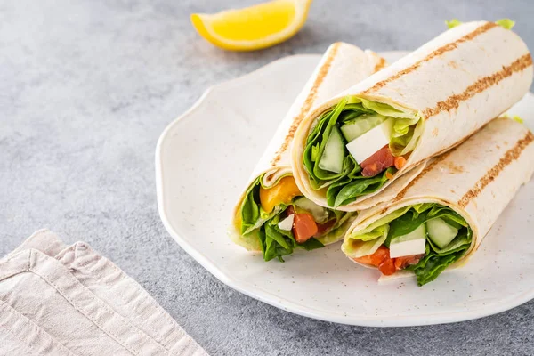 Envuelva el sándwich, rollo con salmón de pescado, verduras y queso. Fondo gris. De cerca. . —  Fotos de Stock