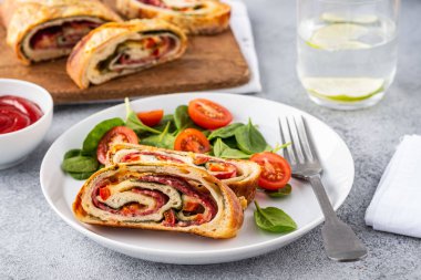 İtalyan yemeği peynirli pizza stromboli, salam, ıspanak ve kırmızı biber..