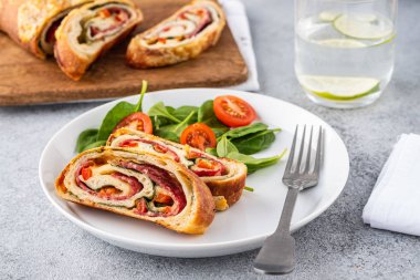 İtalyan yemeği peynirli pizza stromboli, salam, ıspanak ve kırmızı biber..