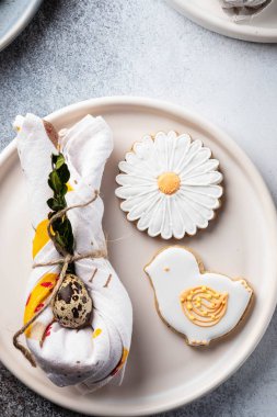 Paskalya tatili için masa ayarı. Fotoğraf beyaz yemekler gösterir, bir peçete içinde mat, Paskalya yumurtası hizmet. Peçete tavşan kulakları altında dökümlü.