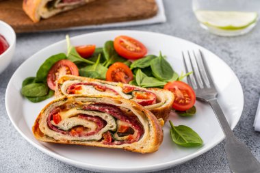 İtalyan yemeği peynirli pizza stromboli, salam, ıspanak ve kırmızı biber..