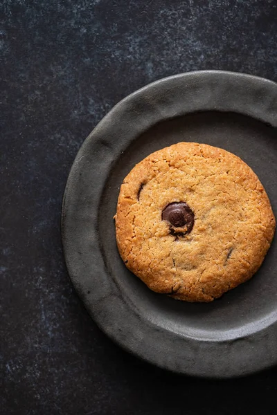 Chocolate chip cookie with hazelnuts, on black background, top view. — Stock Photo, Image