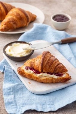 Taze kahvaltı - beyaz tahtada ahududu reçeli ve kruvasan.