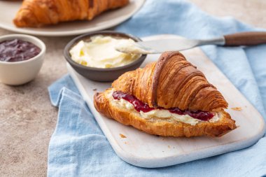 Taze kahvaltı - beyaz tahtada ahududu reçeli ve kruvasan.