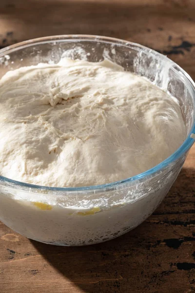 Bowl of fresh raw dough on wooden background. — Stock Photo, Image