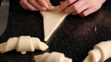 Dişi bir fırıncı pişirmeden önce güzel bir kruvasana dönüşür. Ev yapımı lezzetli hamur işleri çörekler ve kruvasanlar. Geleneksel İtalyan aile pastanesi. Yavaş yemek..