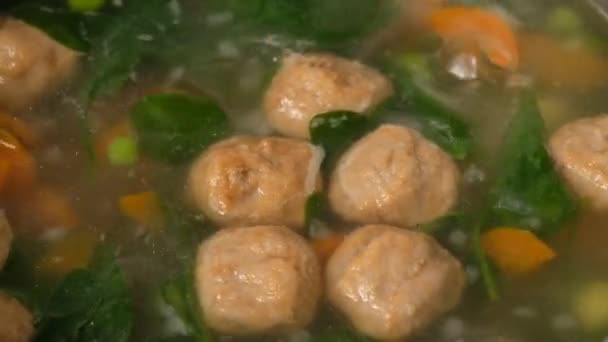 Hausgemachte Gemüsesuppe mit Frikadellen in der Pfanne. Spinat. Nahaufnahme. — Stockvideo