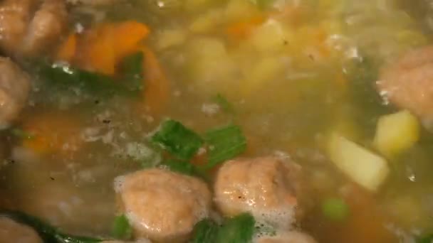 Soupe de légumes maison avec boulettes de viande dans une casserole. Des épinards. Gros plan . — Video