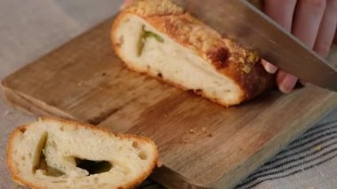 Kadın elleri İtalyan yemeklerini kesiyor peynirli pizza rulo stromboli, mozzarella, salam, domates, ıspanak ve kırmızı biber.
