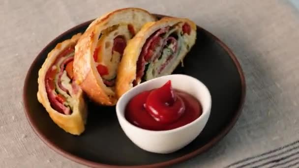 Итальянская еда Pizza roll stromboli с сыром, моцареллой, салями, помидорами, шпинатом и красным перцем на светлом фоне . — стоковое видео