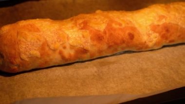 Fırında İtalyan yemeği peynirli pizza rulo stromboli, peynirli mozzarella, salam, domates, ıspanak ve kırmızı biber fırın tepsisi. yavaş çekim