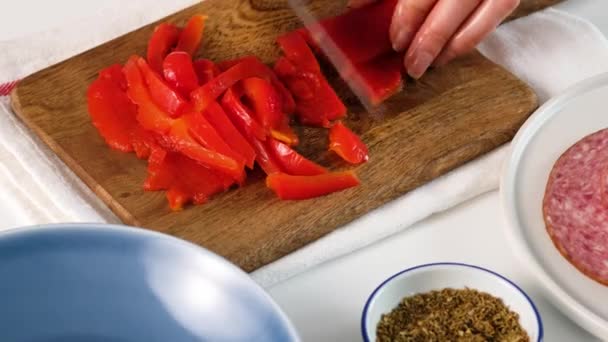 Female hands cuts pepper for Italian food Pizza roll stromboli with cheese, mozzarella, salami, tomatoes, spinach and red pepper. — Stock Video