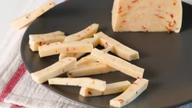 İtalyan yemeği için peyniri kesen kadın elleri. Peynirli pizza, mozzarella, salam, domates, ıspanak ve kırmızı biberli stromboli..