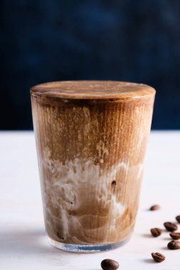 Beyaz ahşap masada sütlü buzlu kahve. Boşluğu kopyala.