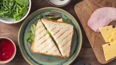 Peynirli sandviç, jambon, domates sosu, ekmek, ahşap arka planda çeşitli dolgularla sandviç yapma süreci, üst manzara, 4k, hareket durdurma animasyonu