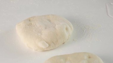 Maya hamuru. İtalyan yemeği için çiğ hamur yapan kadın elleri peynirli pizza, mozzarella, salam, domates, ıspanak ve kırmızı biberli stromboli..