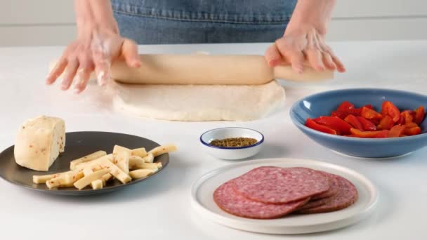 이스트 반죽이요. 치이 즈 , 모차렐라 , 살라미 , 도마도 , 시금치 , 붉은 후추와 함께 이탈리아 음식 피자 를 만들기 위하여 가공되지 않은 반죽을 만들어 내는 여자 손. — 비디오
