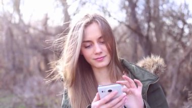 oung kadın bir telefon tutarak ve bir mesaj yazma