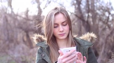 Sarışın kadınla bir smartphone koruyor ve bir telefon numarasını çevirmek