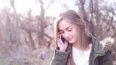 Sarı saçlı genç ve güzel kız bir telefon tutarak ve bir mesaj yazma