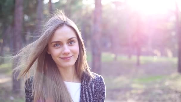 Beautiful young woman is standing in the park — Stock Video