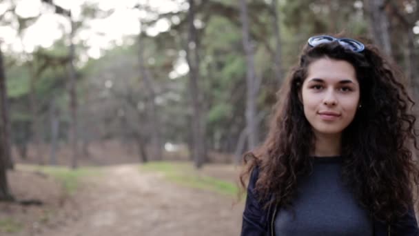 Bastante joven mezcla de raza mujer con el pelo rizado se acerca a la cámara. La chica mira la cámara. Ella tiene hermosos ojos y labios llenos . — Vídeos de Stock