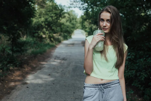 Güzel ve sportif kadın parklar yolda duruyor.