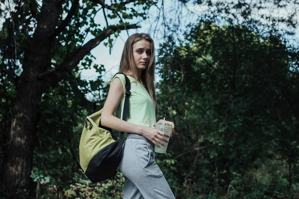 parklar yolda yürüyen uzun saçlı güzel sarışın kadın.