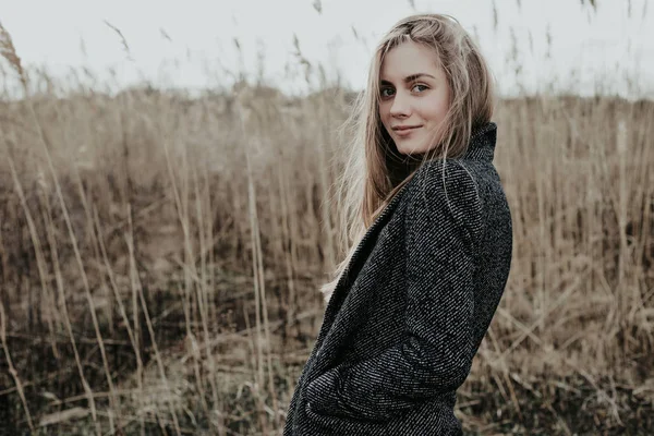 Mooie en verfijnde jonge vrouw met lange blonde haren gekleed in wollen jas — Stockfoto