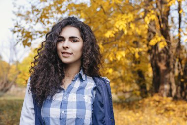 Uzun kıvırcık saç ayakta sonbahar Park olan kadın