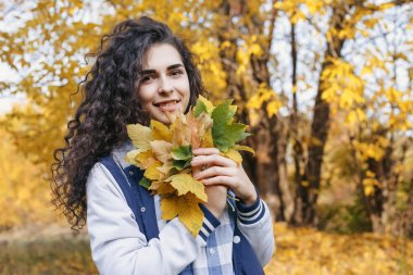 Yaprakları el avuç içinde tutan kız