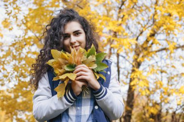 Yaprakları el avuç içinde tutan kız