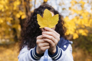 Bir sonbahar sarı yaprak elinde tutan model