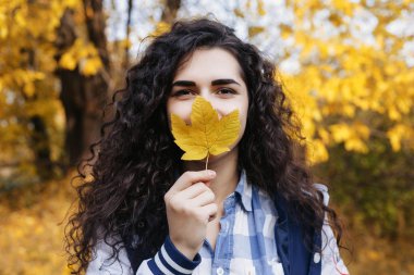 Parkta duran ve kameraya poz genç kız