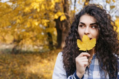 Elinde tutan bir sonbahar sarı yaprak güzel genç kadın