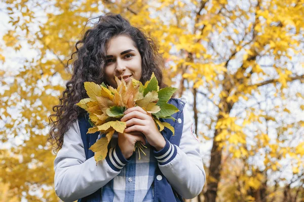 Chica sosteniendo en las manos manojo de hojas — Foto de Stock