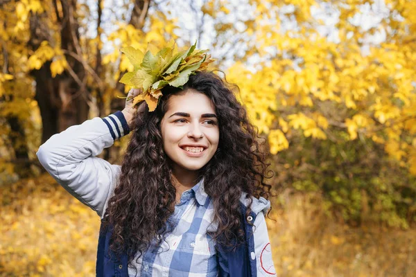 Curly woman holding autumn leaves — Stock Photo, Image